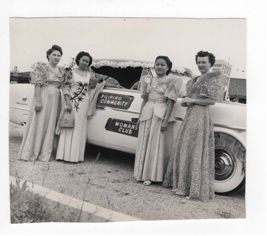 Members of the Filipino Women’s Club posed in front of a car decorated for the 4th of July parade.