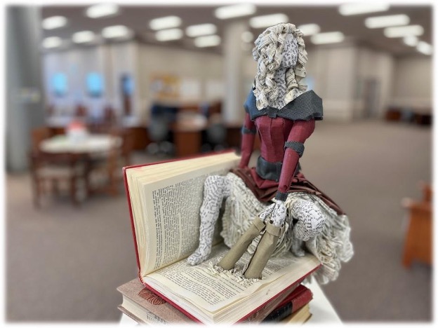 book pages turned into a person sitting atop a book